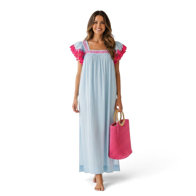 Mer St. Barth Maxi Sandrine sky blue resort dress with pink embroidery and ruffled sleeves on a smiling model